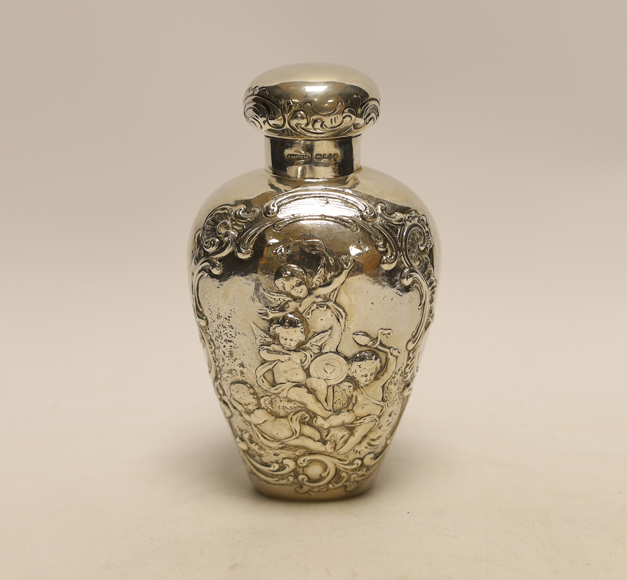 An Edwardian continental embossed silver tea caddy? and cover decorated with amorini, makers stamp to the base, import marks for London, 1902, height 15.8cm, 7.1oz.